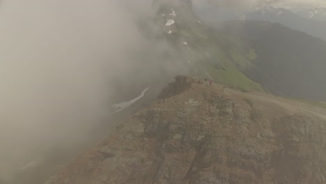 Circling-view-of-a-mountain-summit-reveals-some-hikers-reaching-the-top