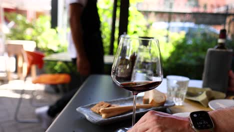 hand holding wine glass at outdoor restaurant