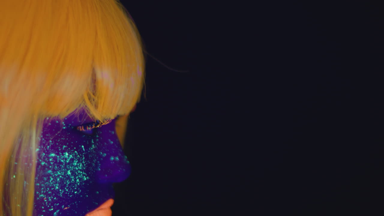 Donna con la vernice per il viso al neon