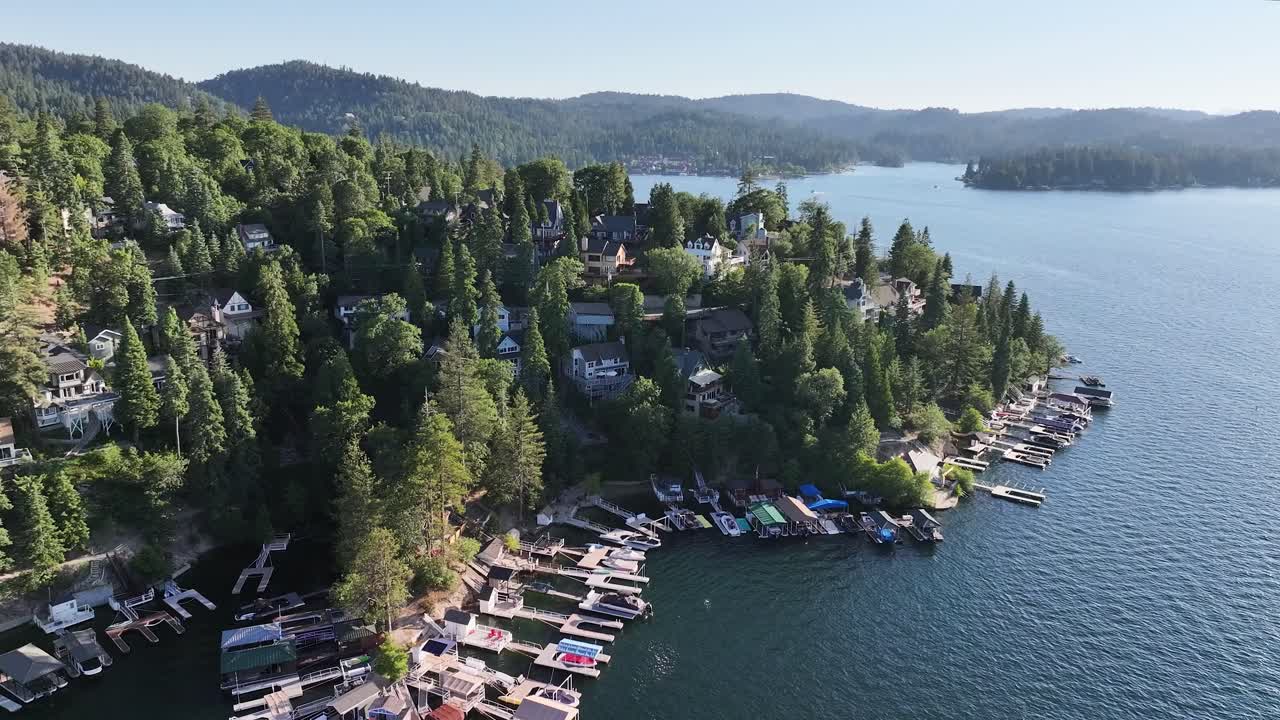 grandes casas en el muelle y en las colinas del lago arrowhead en california durante un día soleado dolly aérea levantar pan derecha