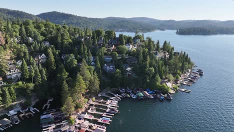 large homes dockside and in the hills of lake arrowhead in california during a sunny day aerial dolly raise up pan right