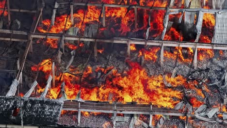 top aerial view of raging flames ravaging a warehouse in industrial area