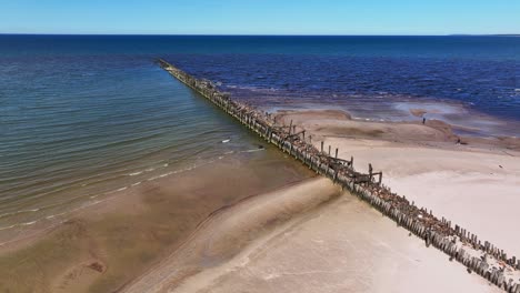 the remains of what used to be an old bridge built on stone and wooden piles to the baltic sea