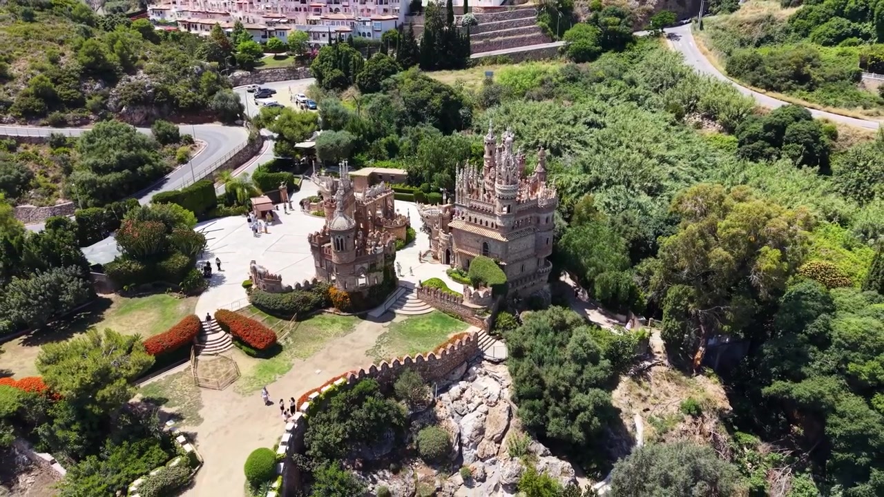 Drone luftfoto af Colomares Slotkompleks med udsmykkede tårne, dekorativ arkitektur, gårdspladser og haver i Benalmádena, Málaga, Andalusien, Spanien.