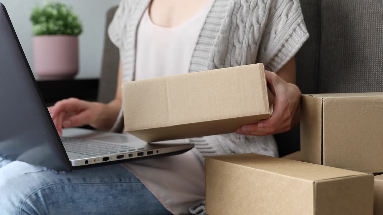 selling from home. small business entrepreneur woman checking mailing box for shipping from online store