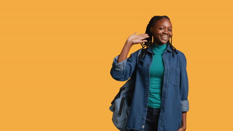 Portrait-of-chipper-girl-waving-hand,-gesturing,-studio-background