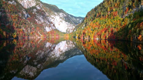 perfect mirror reflections of autumnal forest mountains over lake toplitz, austria