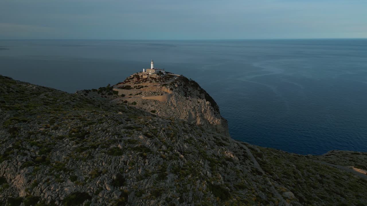해가 지는 시점 에 눈부신 절벽, 산, 바위 형태 를 가진 등대 cap de formentor