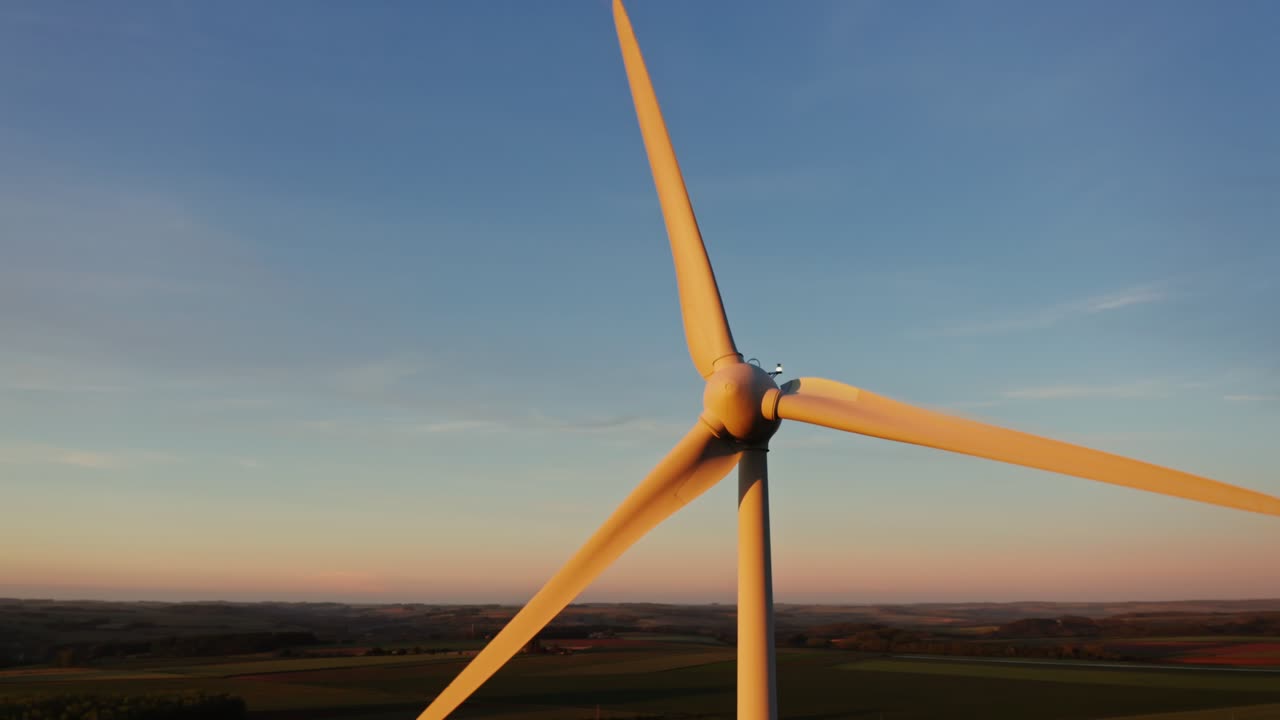 turbina eólica al atardecer sobre campos agrícolas