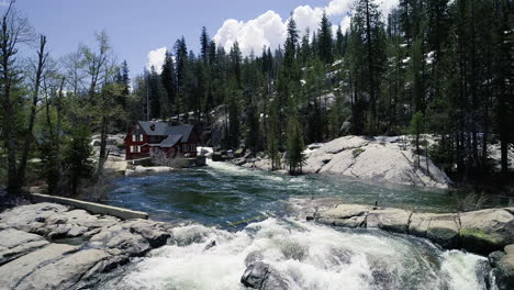 Dolly-Adelante-Revelando-El-Río,-La-Cascada-Y-La-Casa-Roja-Junto-Al-Río.