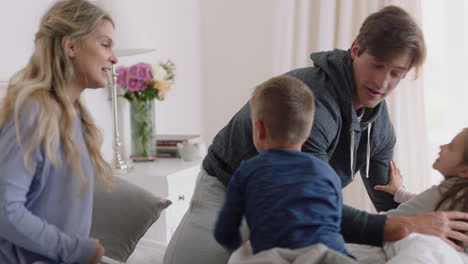 happy family with children jumping on bed playing with mother and father having fun on weekend morning excited little kids enjoying game with parents at home 4k footage