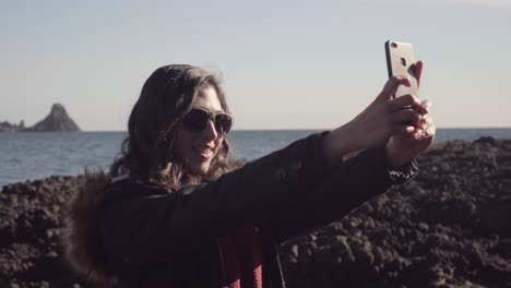 girl takes selfie and pictures in the sunset with beautiful landscape