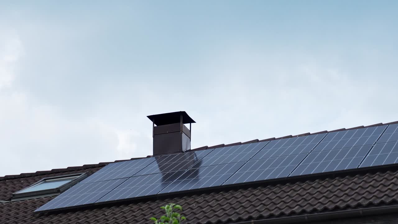 Solar panels on a rooftop under a cloudy sky, symbolizing clean energy timelapse