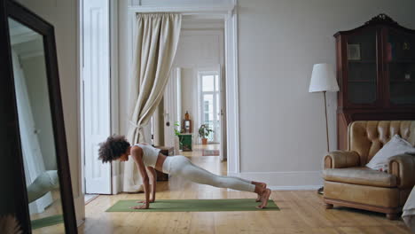 athletic lady yoga training at white room. african girl doing back stretching