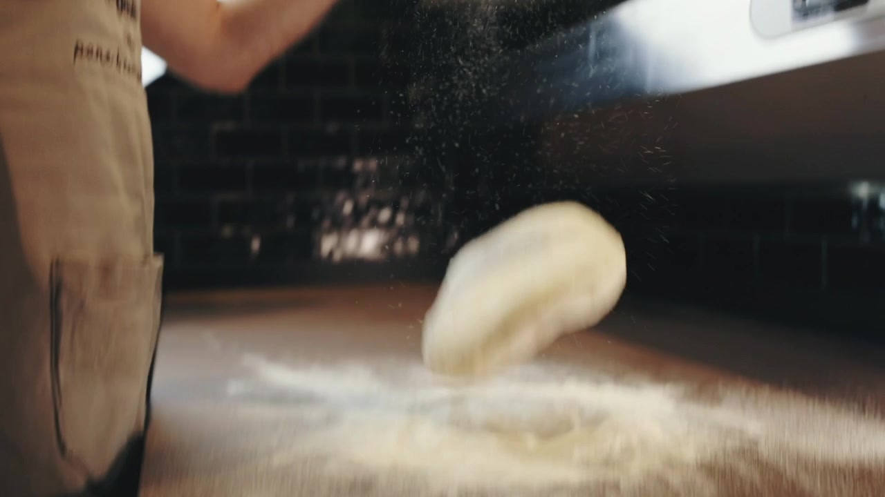 Slow motion Man Drops Dough Ball on Countertop Spatters Flour Sprinkles
