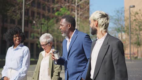 four multicultural business people chatting walking along the city