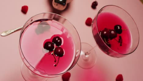 Close-up-of-drinks-with-cherries-and-shaker-on-white-background