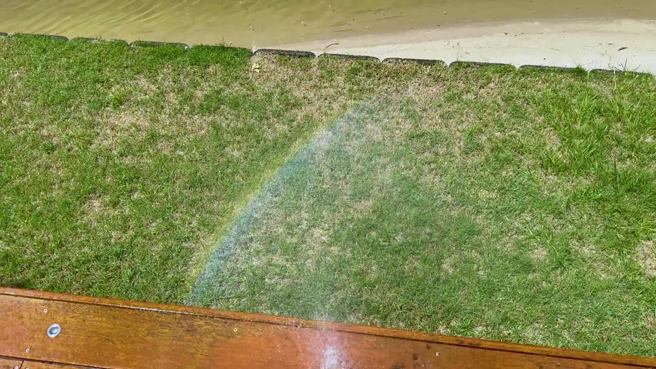 물 스프레이로 풀 위에 무지개가 형성됩니다.