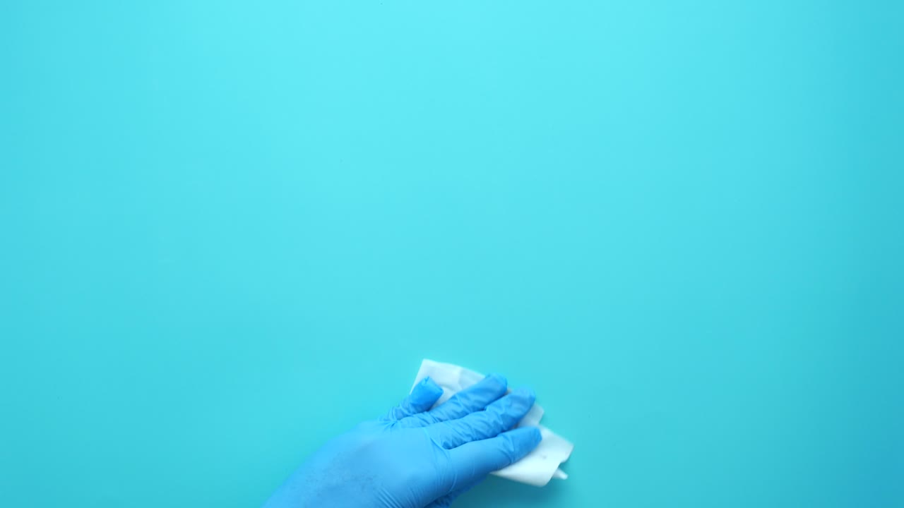 limpieza de una superficie con guantes y una toalla