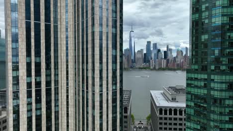 Ein-World-Trade-Center-Gebäude-In-Lower-Manhattan,-Das-Aus-Den-Wolkenkratzern-Von-Jersey-City-Mit-Dem-Hudson-River-Wassertaxiboot-Sichtbar-Wurde