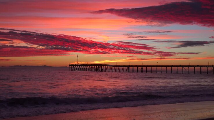 A gorgeous red orange sunset coastline shot along the Central California coast with the Ventura pier distant
