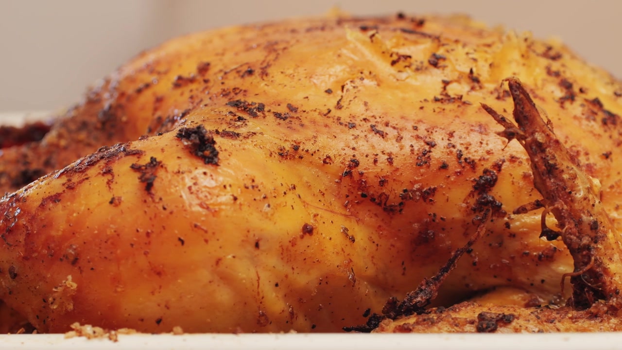 Primo piano di un pollo intero arrosto con pelle croccante dorata