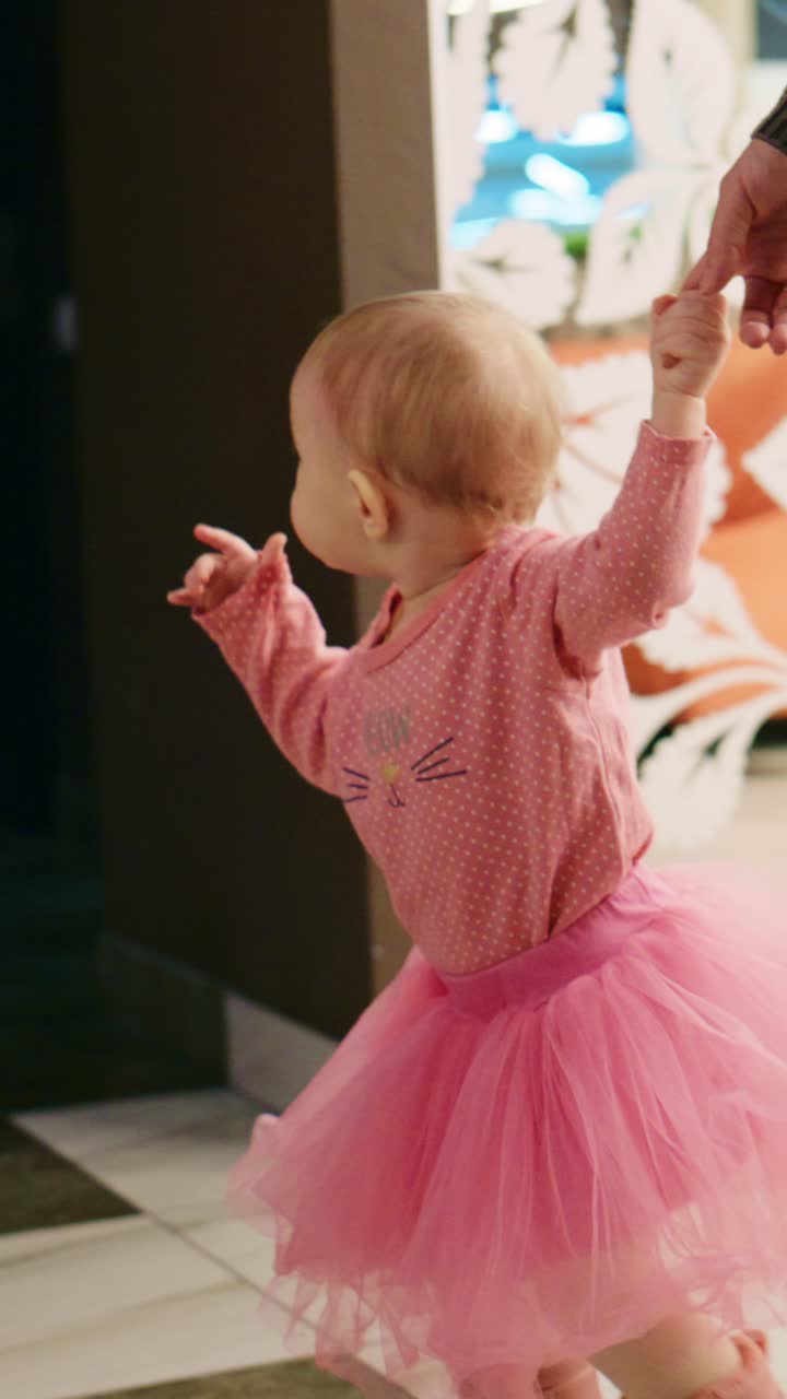 Una bambina gioiosa con un tutù rosa che danza felice, esaltando l'innocenza e la giocosità dell'infanzia in un ambiente luminoso e accogliente