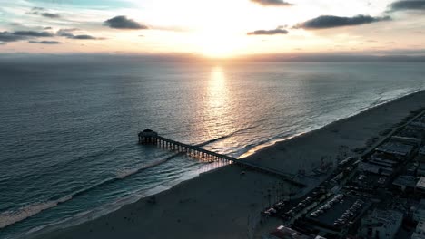 peaceful sunset with reflection on the pacific ocean in manhattan beach pier, california, usa