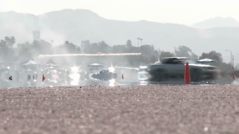 a long shot down the runway of camarillo airport as a white car drifts through a driving course