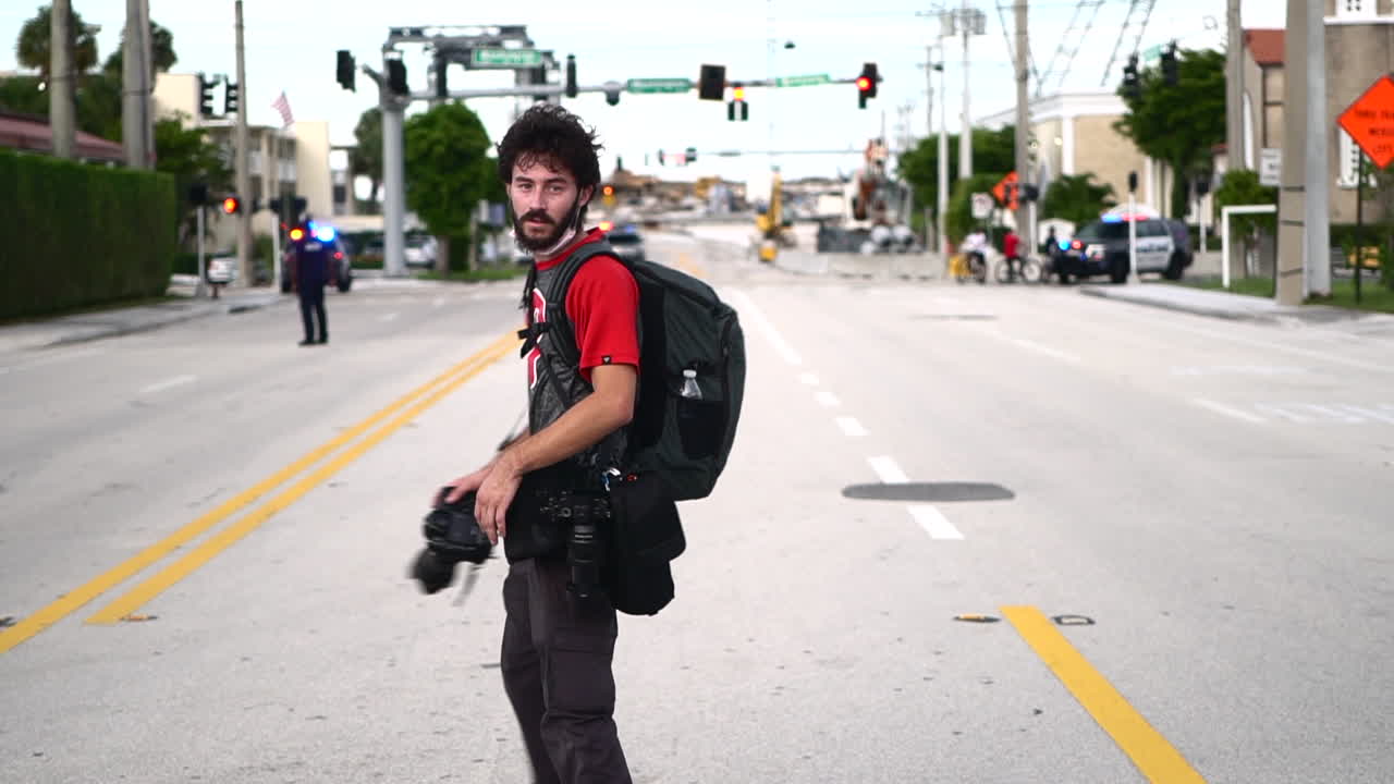 Young black man walking on empty road with camera during Black Lives Matter protest