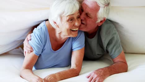 Happy-senior-couple-lying-on-bed-