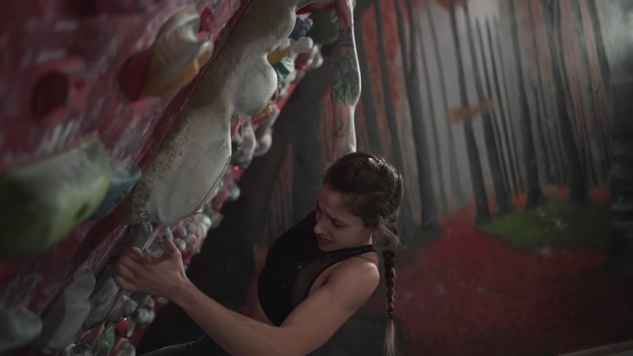 mujer escalando roca en un gimnasio de escalada cubierto