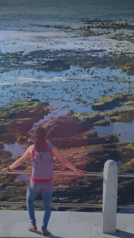 animación de puntos de luz sobre mujer biracial admirando la vista en el paseo marítimo