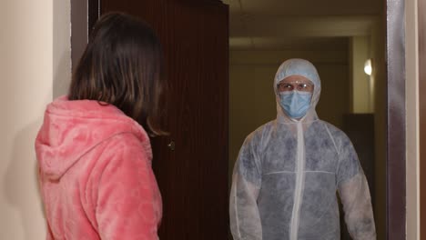 medical worker with text on paper visiting woman at home offering vaccination against coronavirus