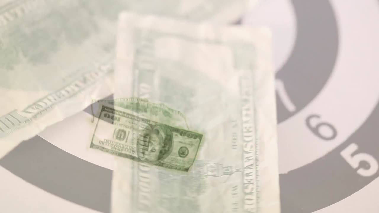 Animation of american dollar bills spinning over bull's eye