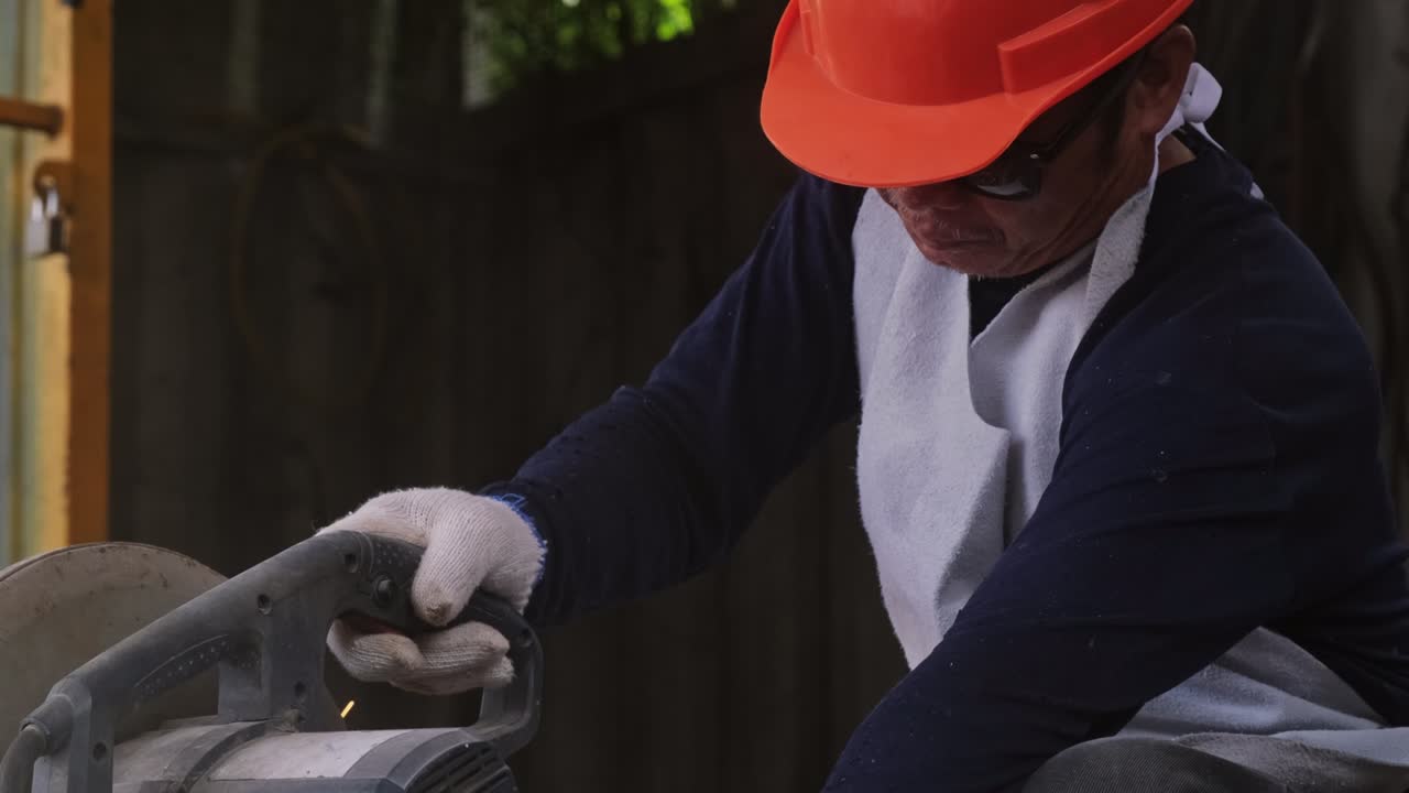 보호 안경과 건설 장갑을 입은 전문 남자들은 전기 강철 절단기 기계로 가정 작업장에서 일합니다. 금속을 절단하면 불꽃이 날아갑니다.