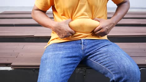 man with a large belly sitting on a bench