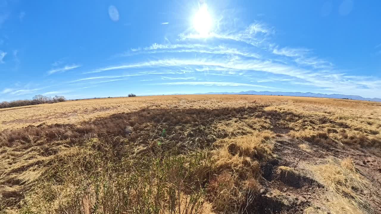 Time lapse of clouds of dry fields of golden grass in Arizona.
