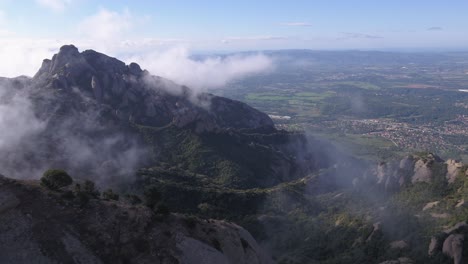 Aerial-cinematic-view-over-Montserrat-mountain-and-valley-in-background,-Catalonia
