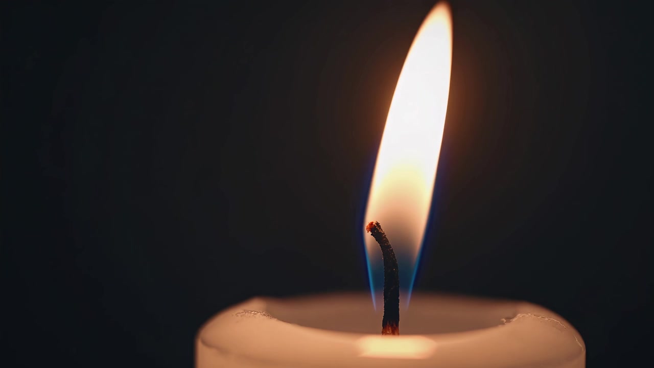 Primo piano di una fiamma di candela accesa al buio