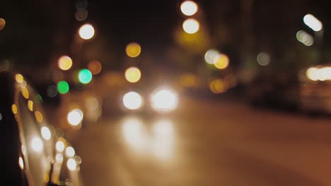 Blurred-vision-of-city-at-night-with-traffic-lights-with-a-car-passing-by