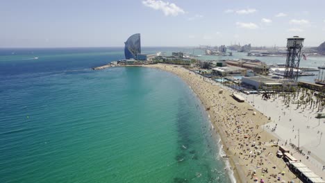 aerial view of barcelona's coastline with a crowded beach and hotel w
