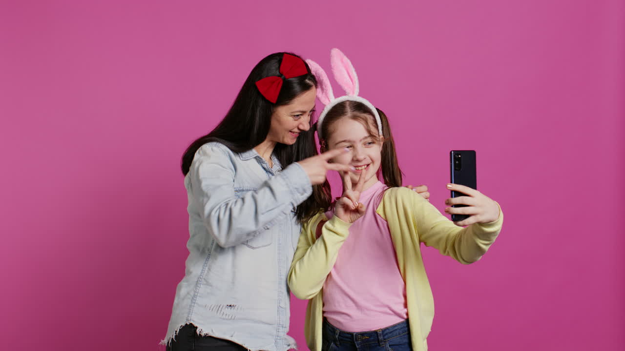 madre alegre y niña sonriendo para las fotos en el teléfono inteligente