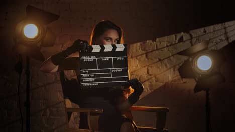 woman holding clapperboard in studio setting
