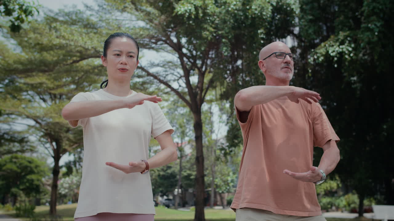 Thoughtful Mature Couple Meditating in Park Practicing Tai Chi