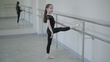 young ballerina practicing dance moves in studio