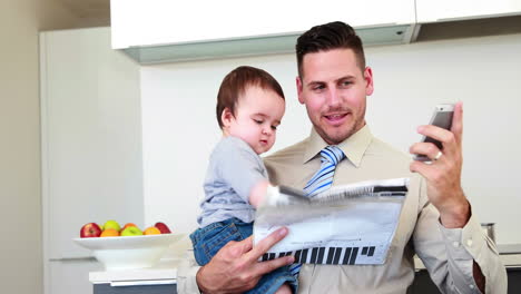 Father-carrying-his-baby-son-before-work-and-talking-on-phone