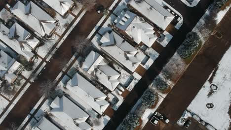 Snowy-rooftops-top-down-drone-view-perspective-as-car-drives-by