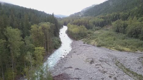 luftaufnahme von stromschnellen des flachen gebirgsflusses der klasse i im niedrigen wolkennebel