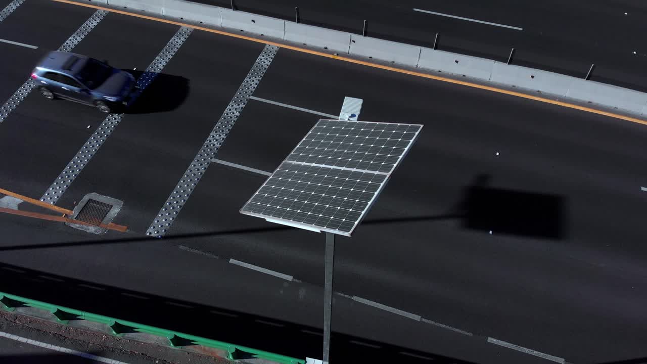 어두운 보행로를 지나가는 고속도로의 태양광 패널의 상단